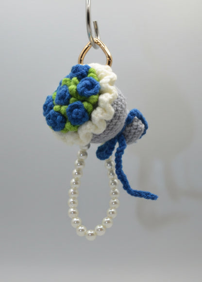 Crocheted keychain with flowers and pearls on a white background