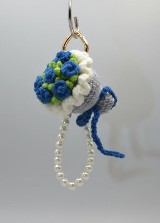 Crocheted keychain with flowers and pearls on a white background
