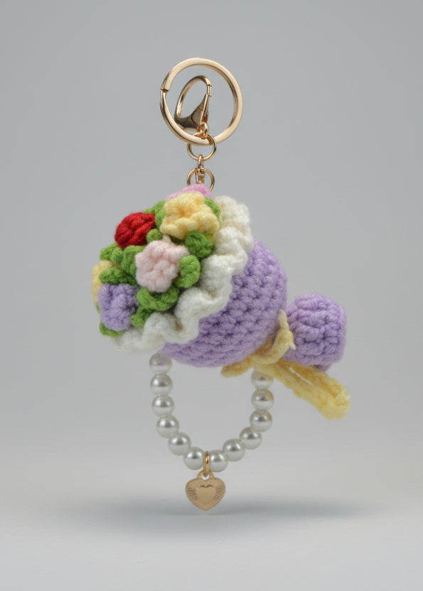 Crocheted keychain with flowers and pearls on a white surface