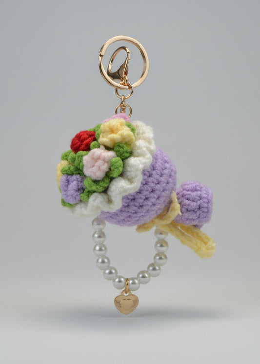 Crocheted keychain with flowers and pearls on a white surface