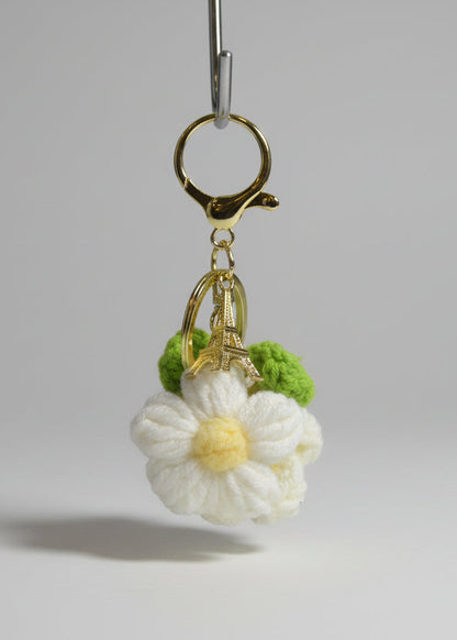 Keychain with a white flower charm on a neutral background